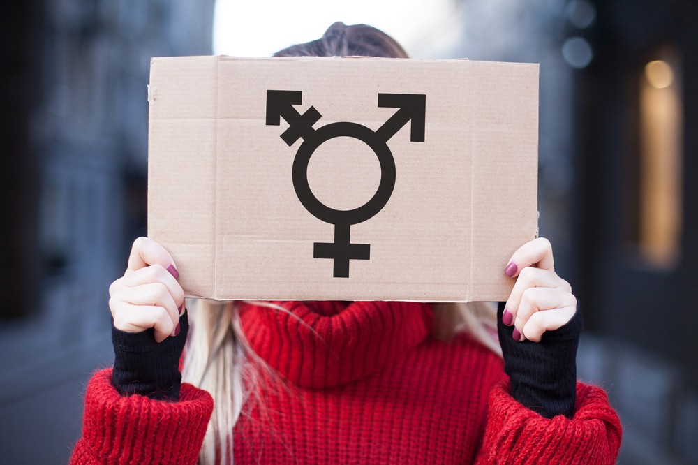 girl holding transgender symbol sign