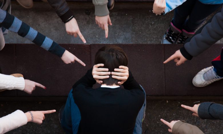 Children bullying a child pointing at him.