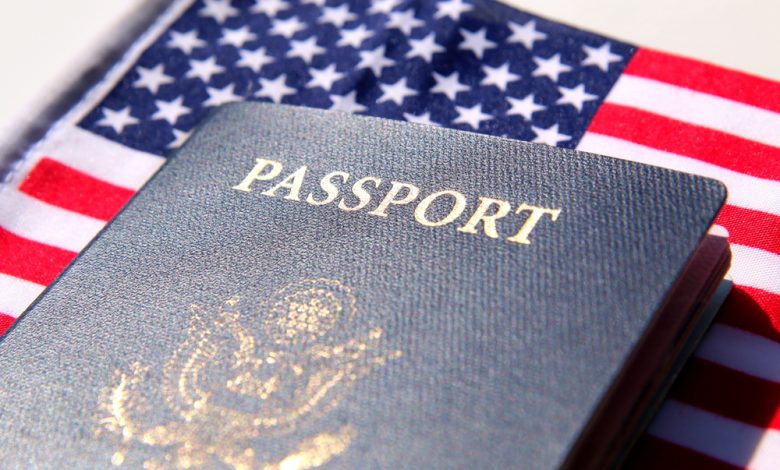 A US passport lays on the American flag.