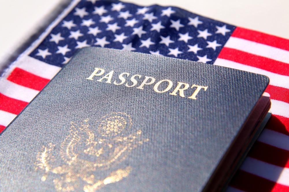 A US passport lays on the American flag.
