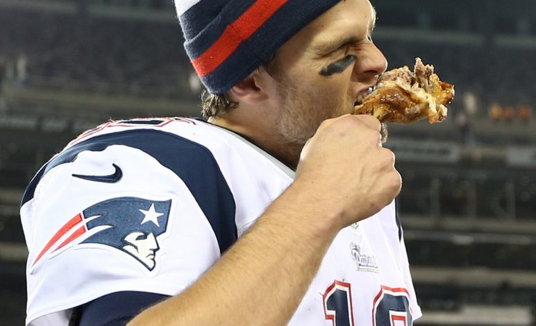 Tom Brady on the sidelines, eating.
