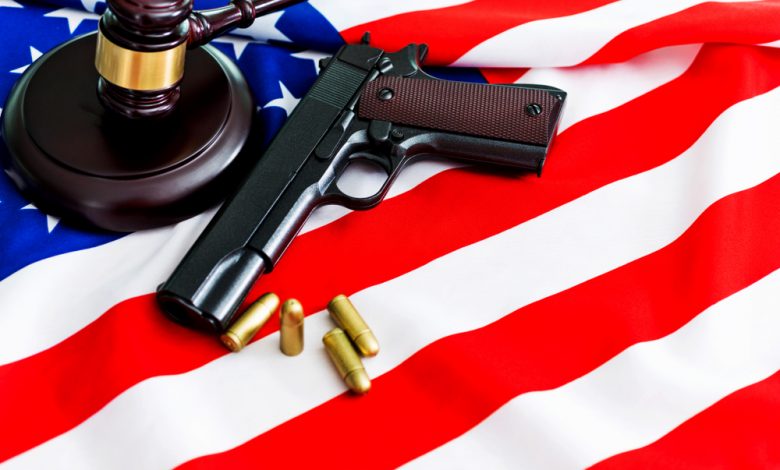 Image of handgun alongside a gavel and american flag.