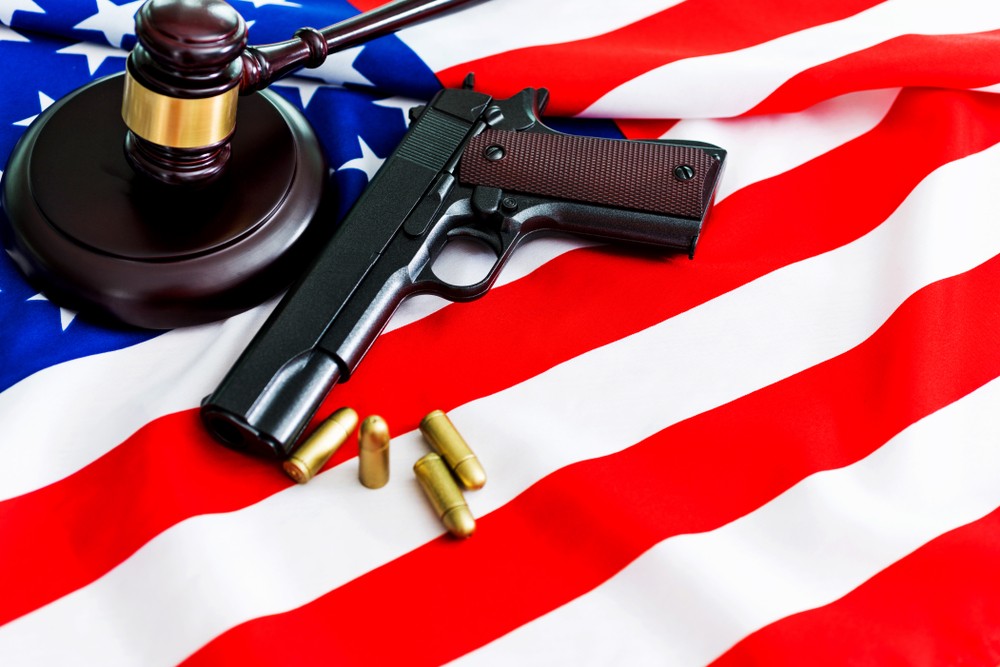 Image of handgun alongside a gavel and american flag.