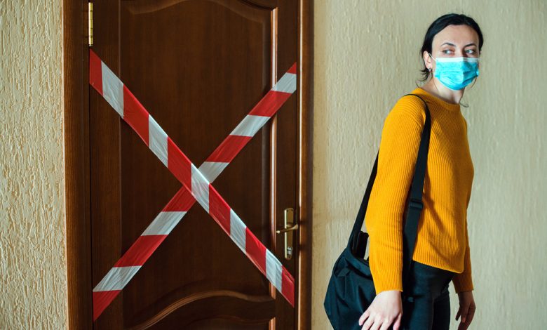 Image of women wearing face masks walking away from quarantined room.