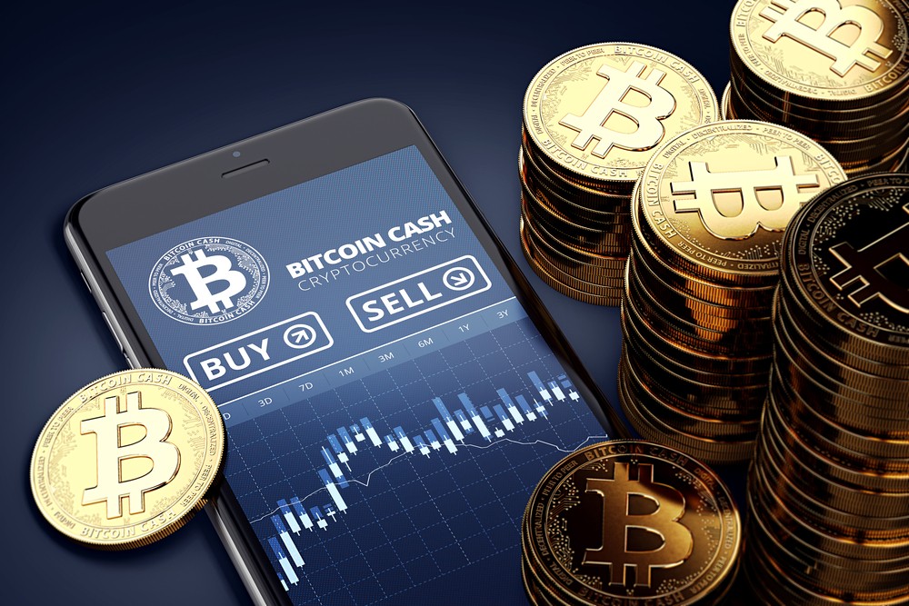 Image of Smartphone with Bitcoin tokens lying around.