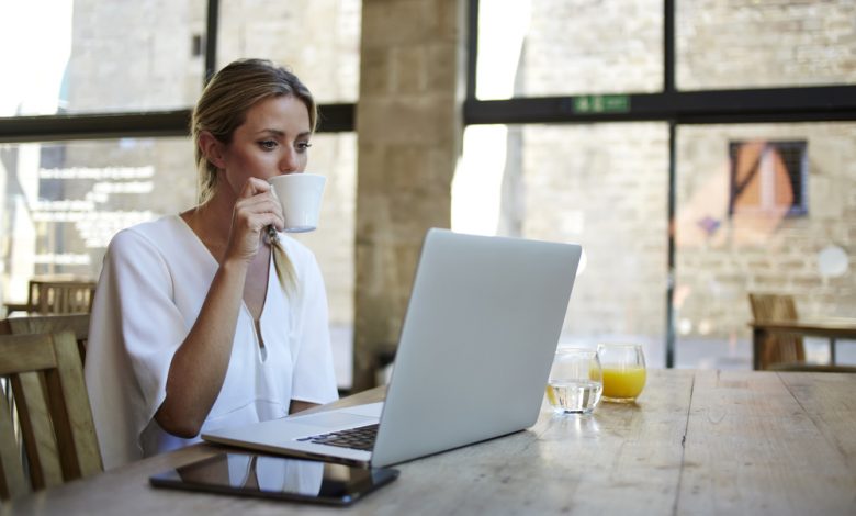 Businesswomen enjoying coffee during work on portable laptop computer.