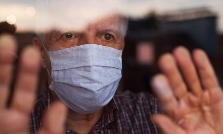 An elderly man wearing a protective face mask in a nursing care home.