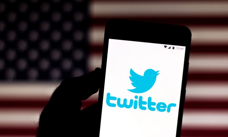 Illustration of the Twitter logo on a smartphone and the American flag in the background.