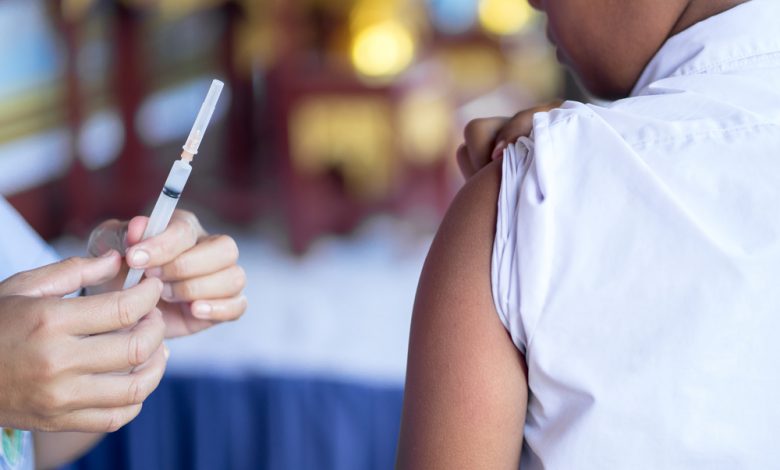 Doctor give vaccine injection to boy's arm.