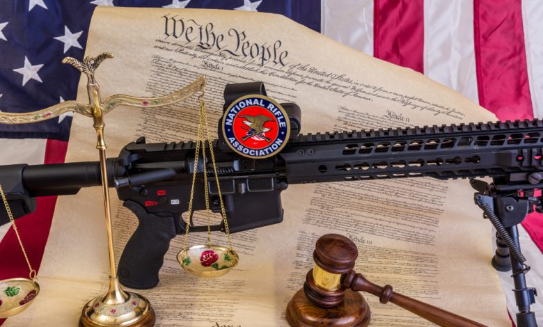 Bill of rights with an American flag, judges gavel and a balance scale dealing with the NRA and the second amendment.