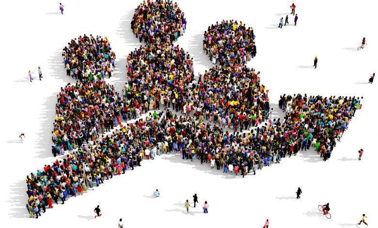 Large and diverse group of people seen from above, gathered together in the shape of a job growth symbol.