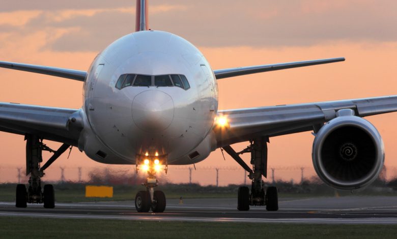 Modern civil passenger airliner taking off at airport during sunset. F By Fasttailwind