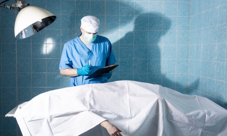 Coroner inspects the body of a deceased person.