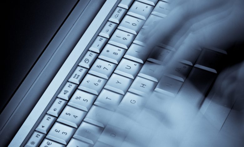 Image of hands typing across a computer keyboard.