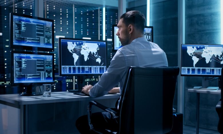 Cybersecurity professional working on his work station with multiple.