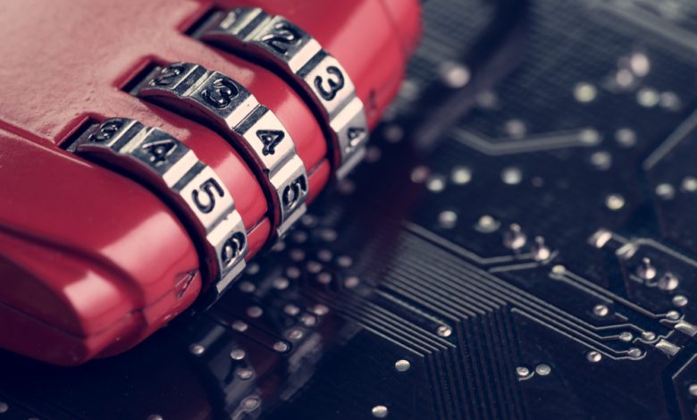 Cybersecurity concept image showing code numbers on a combination padlock on top of a computer circuit board.