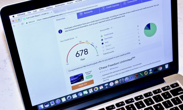 Image of a MacBook displaying the Credit Karma webpage with relevant credit score information.