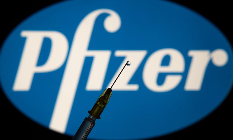 Vaccine shadow over Pfizer Pharmaceutical logo.