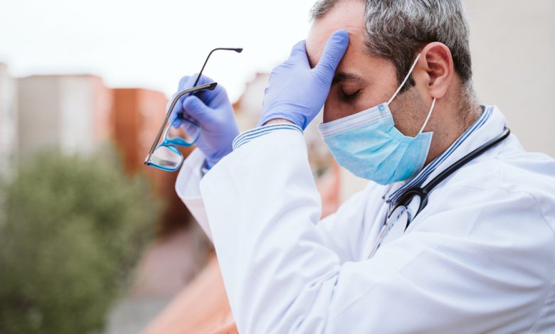 Image showing a doctor exhausted after long hours of treating covid patients.