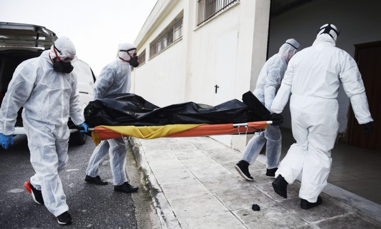 Funeral Home employees carrying the corpse of a COVID-19 victim in a body bag.