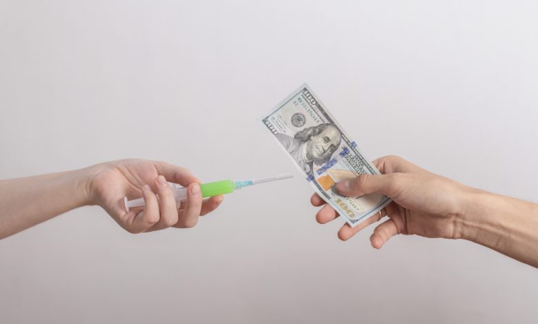 Image showing one hand with a vaccine and another with a $100 bill
