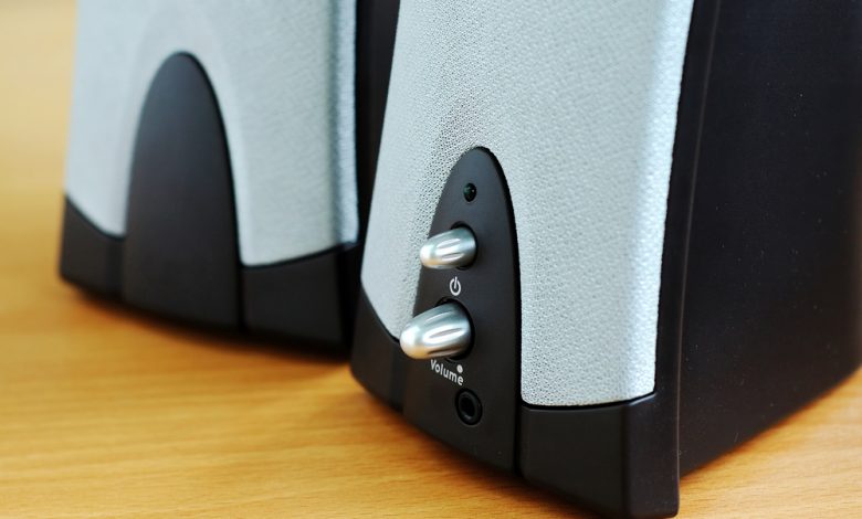 A pair of computer speakers on a desk.