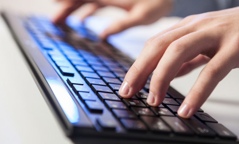 Image of a person typing in a wireless keyboard.