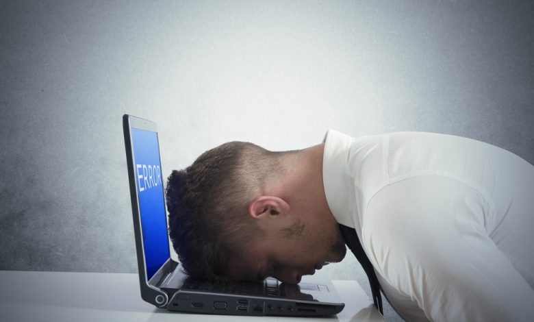 Businessman with blue screen of laptop error.