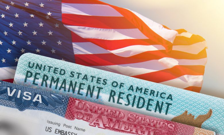 Image showing a US Green Card, a Visa, and an American flag in the background.