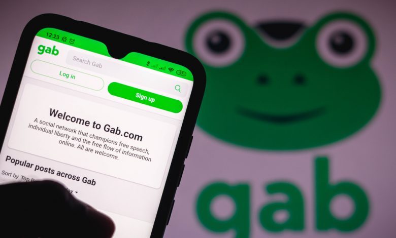 Gab logo seen displayed on a smartphone and in the background.