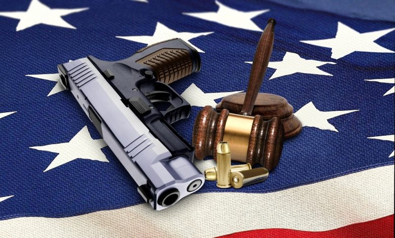 Hand gun with gavel and bullets on ag.merican fla