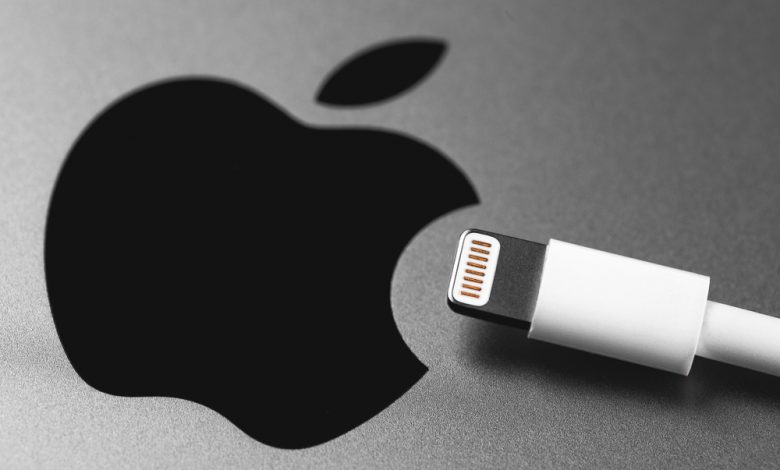 Charging cable and Apple logo on Apple device.