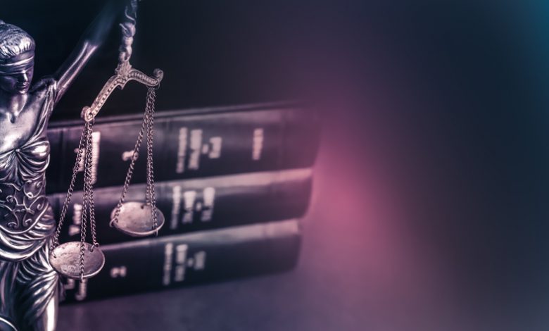 Legal law concept image showing Scales and legal books on a desk.