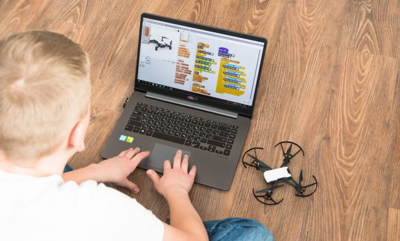 Minsk, Belarus. January, 2019. A teenager boy programs a drone copter Tello DJI on a laptop Asus in a scratch program. STEM and STEAM education. Modern technology and gadgets.