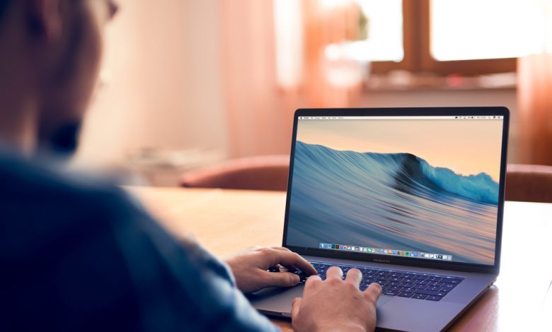 Cracow, Poland - December 6, 2016: Man using Brand new apple Macbook Pro 15 inch late 2016 with touchbar lying on table in home interior.