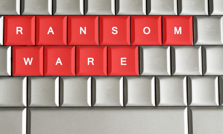 Ransomware written on metallic keyboard in red