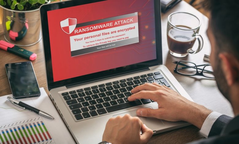 Ransomware alert message on a laptop screen - man at work