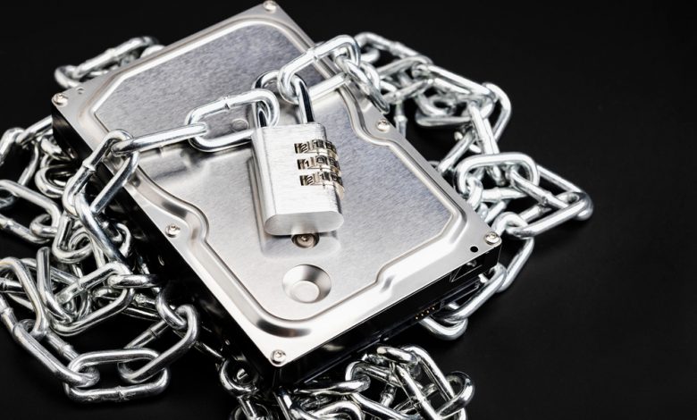 Combination key locked with metal chain and hard disk on a black background , Security and safety concept