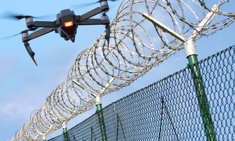 Drone monitoring barbed wire fence on state border or restricted area. Modern technology for security.