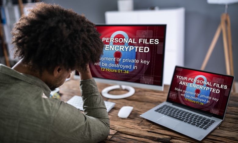 Close-up Of Worried Businessman Encrypted Text On The Laptop Over The Wooden Desk