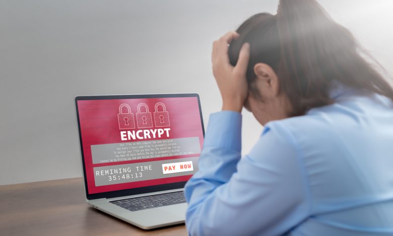 Stressed business woman with computer screen showing personal files encrypted text, Ransomware malware attack. Business computer Hacked. files encrypted.