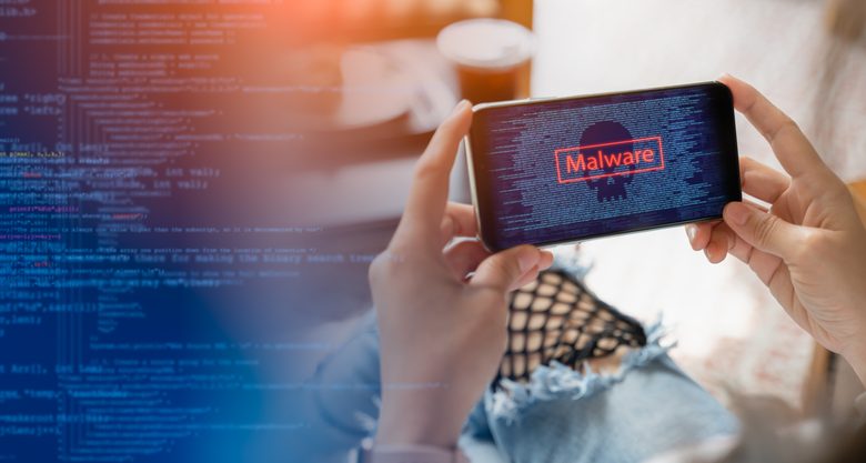 Malware,cyber crime and Personal Data Protection Act concept.Close up hand of anonymous hacker and uses a malware with mobile phone to hack password the money from Bank accounts and personal data.