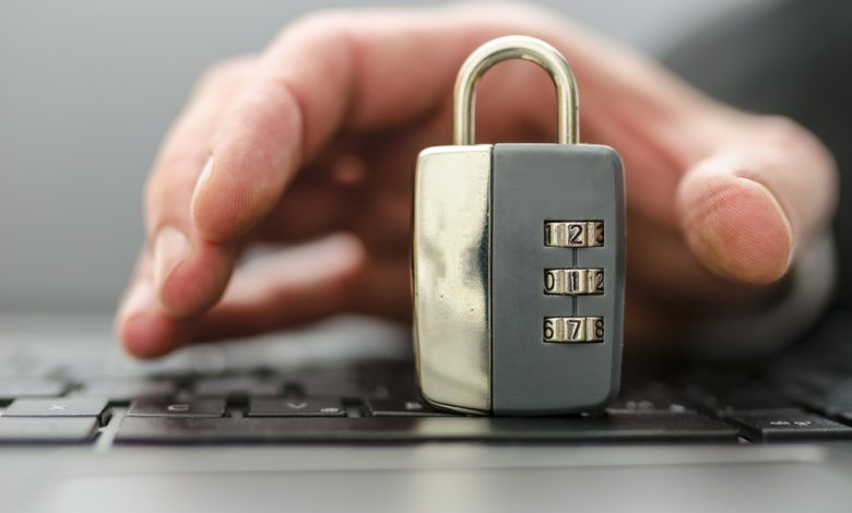 Male hand stealing padlock off computer keyboard.