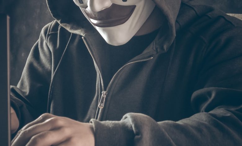 a person wearing a mask using a laptop