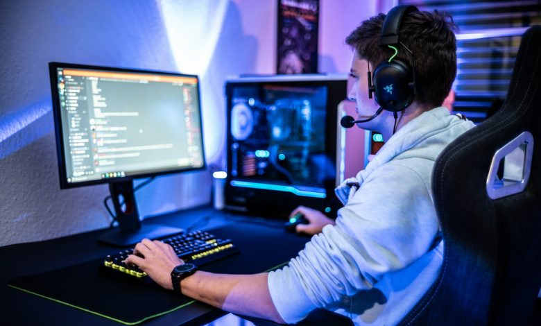 a man wearing a headset sitting at a computer desk