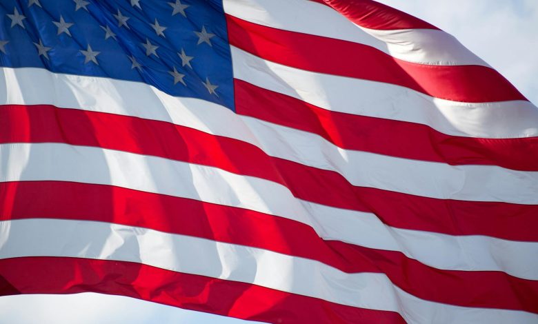 Close-up of the USA flag waving in the wind, symbolizing patriotism and freedom.
